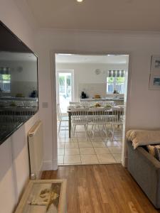 a living room and dining room with a table at Waters Reach in Abersoch +11 photos