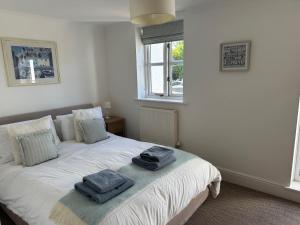 a bedroom with a white bed with towels on it at Waters Reach in Abersoch