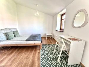 a living room with a bed and a desk at OLD TOWN Olsztyn in Olsztyn