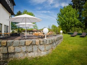 a stone wall with a table and an umbrella at Kaiserhof Feldberg by Belvilla Resorts in Feldberg