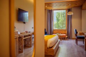 a hotel room with a bed and a desk at Hotel Rewa Ladakh in Leh