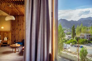 a room with a window with a view of the mountains at Hotel Rewa Ladakh in Leh