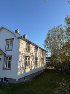 a white house with a shadow on the side of it at Lofoten Town Villa I Sleeps 9 in Leknes
