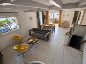 a living room with a couch and a table at Sol-Y-Days Avenue Camargue, grande maison proche centre et mer in Le Grau-du-Roi