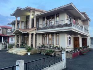 a large house with a balcony on a street at Salena Homestay in Cherrapunji