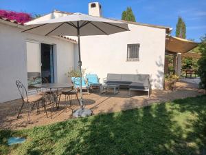 a patio with a table and chairs and an umbrella at Chambre Bed and Breakfast dans la Villa Cypra in Antibes