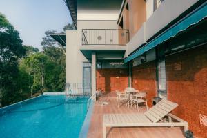 a house with a swimming pool with a table and chairs at Kayn by spynora in Vythiri