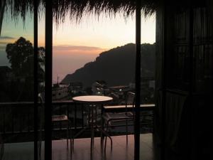 a table and chairs on a balcony with a view at ผาฮี้แลนด์โฮมสเตย์ in Mae Sai