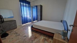 a bedroom with a bed and two large windows at Via del Mare in Termoli