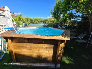 a swimming pool in a yard with a wooden table at Pavillon de Diane in Prades