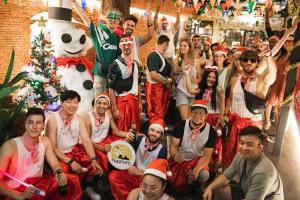 a group of people dressed in christmas costumes posing for a picture at Nappark Hostel @Khao San in Bangkok