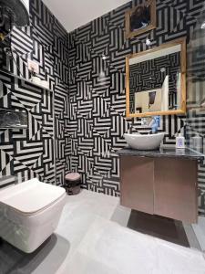 a bathroom with a black and white patterned wall at Cozy Loft 201 2 BHK in Jaipur