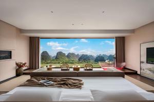 a bedroom with two beds and a large window at 自由鸟觅野山舍-阳朔十里画廊遇龙河店 in Yangshuo