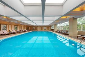 a large swimming pool with chairs in a building at Sunworld Dynasty Hotel Beijing Wangfujing in Beijing