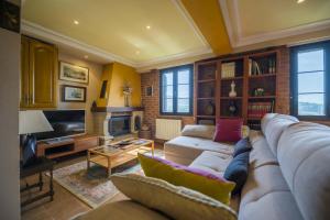 a living room with a couch and a tv at Casa Familiar Etxabe-Enea in Lasarte