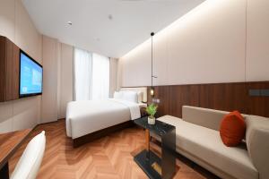 a hotel room with a bed and a couch at 上海安鉌蓓斯特酒店国家会展中心虹桥机场店 in Hongqiao Intl