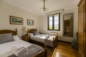 a bedroom with two beds and a window at Casa Familiar Etxabe-Enea in Lasarte