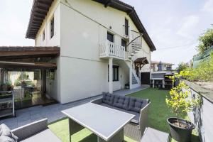 a patio with a white table and a couch at Casa Familiar Etxabe-Enea in Lasarte