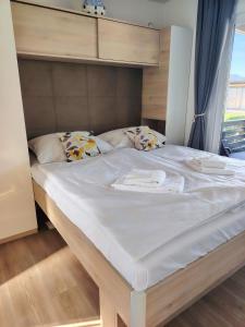 a large bed with white sheets and pillows at Izzi Mobile Home - Terra Park SpiritoS in Kolan