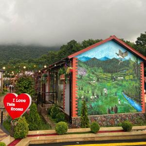 a building with a large mural on the side of it at TALA ROOMS Hotel in Zaqatala +7 photos