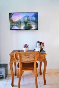 a wooden table with a chair and a picture on the wall at Tegeg's Homestay in Keramas