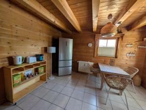 a kitchen with a table and a refrigerator in a cabin at FeWo Aus'm Garten im Holzblockhaus nähe Aachen in Eschweiler +6 photos