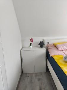 a bedroom with a bed and a nightstand with a plant on it at Melba Vendégház in Dömsöd