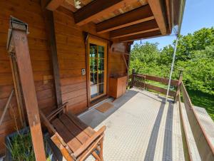 a porch of a wooden cabin with a swing at FeWo Aus'm Garten im Holzblockhaus nähe Aachen in Eschweiler