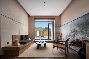 a living room with a couch and a table at 自由鸟觅野山舍-阳朔十里画廊遇龙河店 in Yangshuo