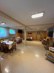 a dining room with tables and chairs in a room at Poteca Ursului in Arefu