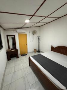 a bedroom with a bed and a yellow door at Luckwin Guest in Anuradhapura