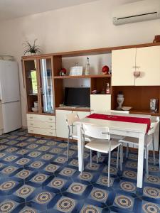 a kitchen with a table and some chairs and a table and a refrigerator at Meraviglioso in Cozze