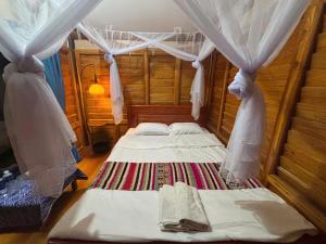 a bedroom with two beds in a room with curtains at Homestay Hùng Phát Pù Luông in Làng Chiêu