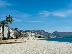 a sandy beach with palm trees and the ocean at Casa LoIa Altea By DelucaCo in Altea