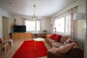 a living room with a couch and a red rug at Villa Golden Haven in Rovaniemi