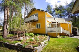 a yellow house with a garden in front of it at Villa Golden Haven in Rovaniemi