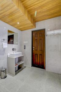 a bathroom with a sink and a wooden door at Banari Regency by Summit in Namchi +28 photos