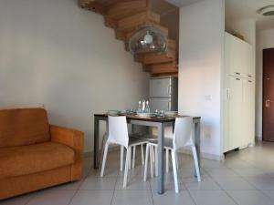een keuken met een tafel en stoelen en een bank bij Casa Letizia in Porto Pino