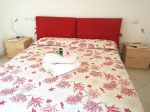 Schlafzimmer mit einem Bett mit rotem Kopfteil in der Unterkunft Casa Letizia in Porto Pino