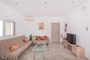 a living room with a couch and a tv at Pastida Olive Home in Pastida +13 photos