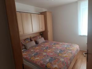 a bedroom with a bed with a floral bedspread at Guest house Gloria in Šilo