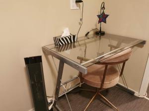 a glass desk with a chair in a room at Love Capilano in North Vancouver