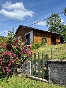 a fence in front of a house with flowers at Refuge nature de Aumontzey in Granges-Aumontzey