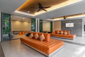 a living room with two orange couches and a ceiling fan at Kata Sea Breeze Resort - SHA Plus in Kata Beach