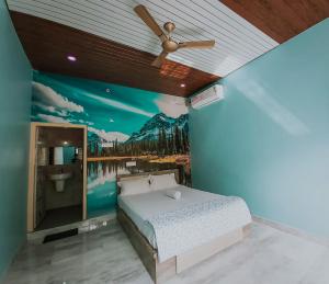 a bedroom with a bed with a painting on the wall at Hampi Banana Farm House in Hospet