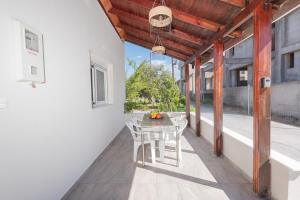 a patio with a table and chairs on a balcony at Pastida Olive Home in Pastida