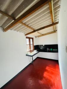 an empty room with a red floor and a window at Moon Light Villa in Panama