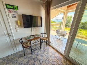 a room with a table and chairs and a sliding glass door at Seafront blue in Áyios Spirídhon