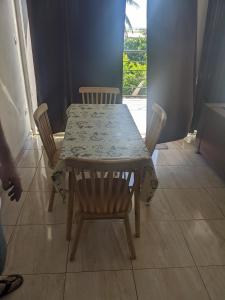 a table and chairs with a table and a window at Appartement VIDA 1 in Mahajanga