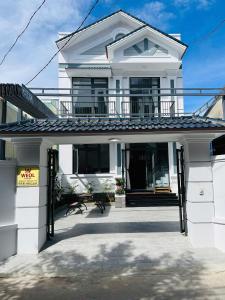 a white house with a porch and a balcony at weolhouse in Hue
